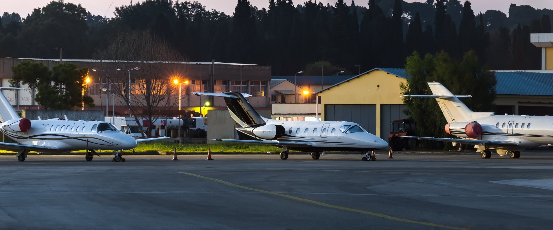 three private jets on stand parked at the airport